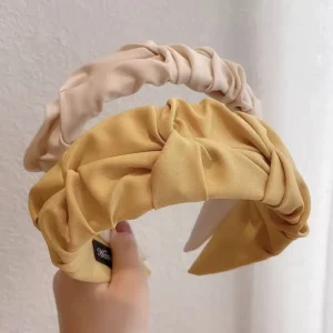 Place a headband at the crown of your head, pushing hair back. Adjust for comfort.